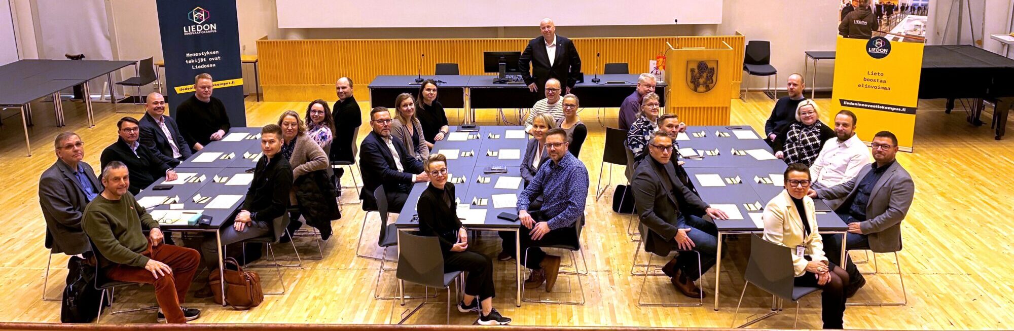 Yrittäjyyden neuvottelukunnan osallistujat ja Liedon kaupunginjohtaja pöytien äärellä valtuustosalissa.